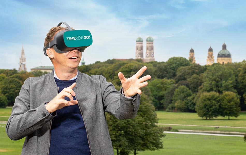Mann im englischen Garten mit VR-Headset sieht sich staunend um.